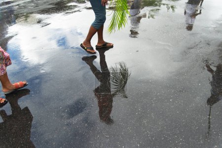 Photo for Salvador, Bahia, Brazil - April 14, 2019: Catholics are seen, in reflection on the wet ground, holding plants during the Palm Sunday celebration in the city of Salvador, Bahia. - Royalty Free Image