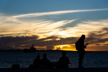Foto de Salvador, Bahia, Brasil - 13 de abril de 2019: Los turistas son vistos en Ponta de Humaita disfrutando de la dramática puesta de sol en la ciudad de Salvador, Bahia. - Imagen libre de derechos