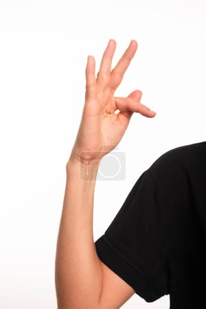 Foto de Primer plano de un brazo y una mano femeninos haciendo la letra F en el lenguaje de señas brasileño para sordos, Libras. Salvador, Bahia. - Imagen libre de derechos