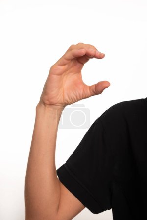 Großaufnahme eines weiblichen Arms und einer Hand, die den Buchstaben C in der brasilianischen Gebärdensprache für Gehörlose, Libras, herstellt. Salvador, Bahia.
