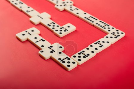 Dominoes with red background, copy space and various angles, board games concept.