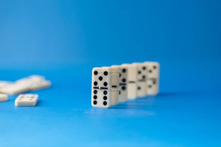 Dominosteine stehen auf blauem Grund. White Bones Brettspiel.