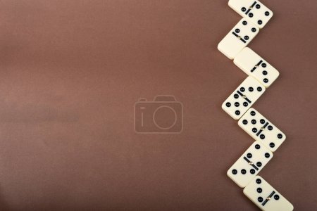 Dominoes on a brown background. White Bones Board Game.