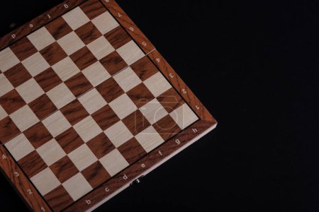 Foto de Tablero de madera vacío de damas o ajedrez sobre fondo negro. - Imagen libre de derechos