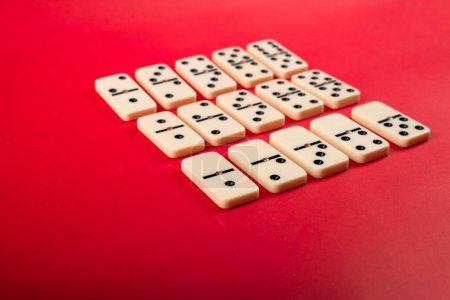 Dominosteine mit rotem Hintergrund, Kopierraum und verschiedenen Winkeln, Brettspielkonzept.