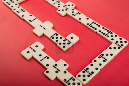 Dominoes with red background, copy space and various angles. White Bones Board Game.