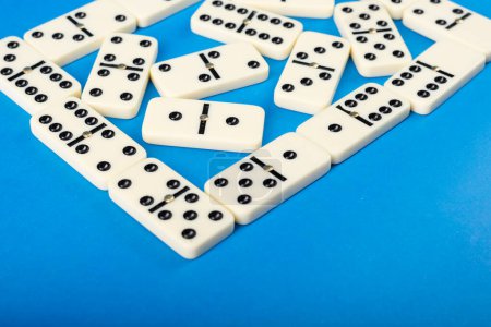  Verbundene Dominosteine auf blauem Hintergrund. Brettspielkonzept