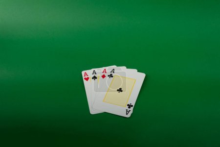 Playing card for poker and gambling, four aces. Isolated on green background.
