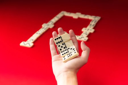 Domino-Spieler mit rechteckigen Acrylteilen. Brettspiel. Roter Hintergrund.