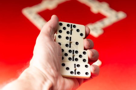 Domino-Spieler mit rechteckigen Acrylteilen. Brettspiel. Roter Hintergrund.