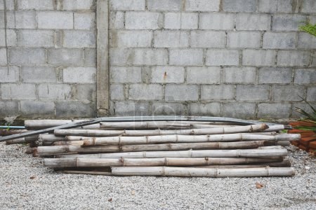Ein Haufen Bambusstäbe wurde gegen die Wand gestapelt.