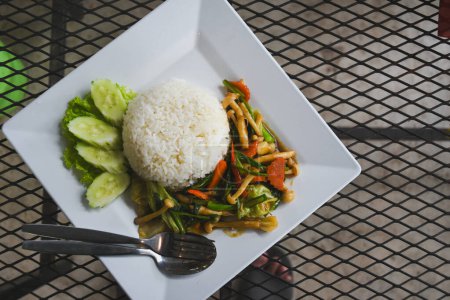 Stir-fried vegetables over rice in a plate on the table