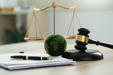 Law international environmental concept.world and wooden gavel with a golden scale.Law for environmental regulation.Sustainable environment concept.Green law.