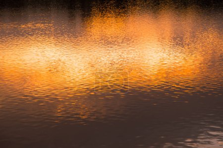 Téléchargez les photos : Fond flou d'eau de surface au coucher du soleil - en image libre de droit