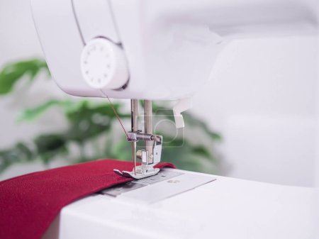 Photo for Close up of sewing machine working with red fabric,  stitch new clothing. - Royalty Free Image
