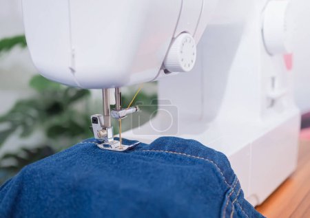 Téléchargez les photos : Gros plan machine à coudre coudre couture de jean denim bleu. - en image libre de droit