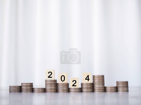 Foto de Bloque de madera con número 2024 en pila de monedas. El concepto de ahorro de dinero, finanzas, inversiones y negocios en crecimiento en el nuevo año 2024. - Imagen libre de derechos