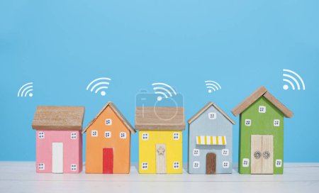 Téléchargez les photos : Maison miniature avec signal Wifi. Le concept de connexion réseau, internet des objets, contrôle de la maison intelligente et la technologie du système d'automatisation - en image libre de droit