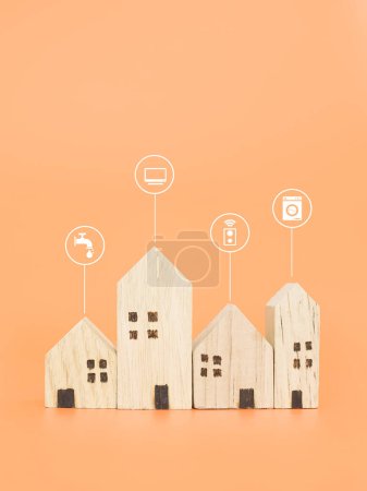 Téléchargez les photos : Maison miniature avec des icônes de maison intelligente. Le concept de contrôle à domicile intelligent et la technologie du système d'automatisation pour tout dans la maison. - en image libre de droit