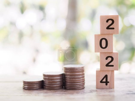 Wooden blocks with the number 2024 and stack of coins. The concept of saving money, Financial, Investment and Business growing in year 2024.