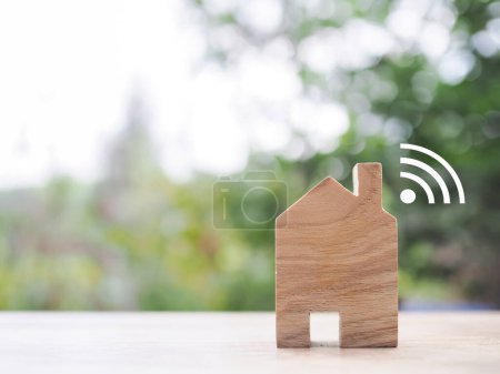Téléchargez les photos : Maison miniature avec signal Wifi. Le concept de connexion réseau, internet des objets, contrôle de la maison intelligente et la technologie du système d'automatisation - en image libre de droit