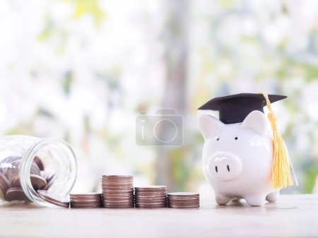 Piggy bank with graduation hat and stack of coins. The concept of saving money for education, student loan, scholarship, tuition fees in the future