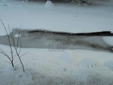 Detalle de disparo: Río Ostravice congelado en las montañas checas cubiertas por una capa de hielo y nieve durante el día de invierno nevado