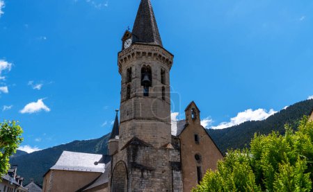 Téléchargez les photos : La ville de Vielha dans la vallée de l'Aran, Lleida, Catalogne, Espagne. Le temple est au centre de la ville, contre un ciel bleu vif. Paysage urbain dans une ville de montagne. - en image libre de droit