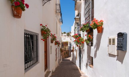 Traditionelle weiße Häuser an der Costa Blanca, Spanien. Schöne Straße mit Blumen. Ruhige Straße in einem kleinen Dorf mit vielen bunten Blumensträuchern und weißen Häusern.