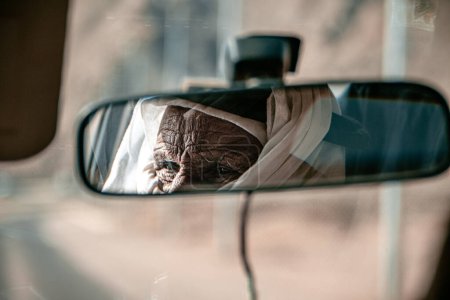 Téléchargez les photos : L'homme bédouin est vu dans le rétroviseur d'une voiture - en image libre de droit