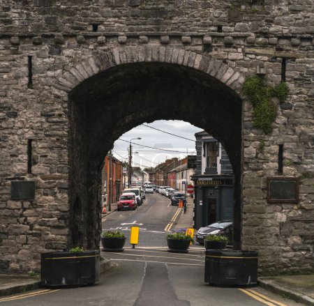 Photo for A view of a city street through an antic archway, Ireland - Royalty Free Image