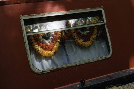 Téléchargez les photos : Londres - 05 21 2022 : Fenêtre d'une péniche avec guirlandes fleuries amarrées sur le Canal de la Grand Union - en image libre de droit