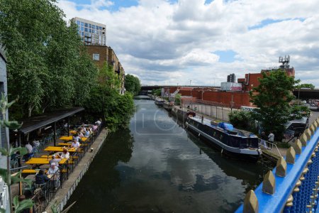 Photo for London - 05 21 2022: View from Ponte Bridge 4c on the Great Western Road on the Grand Union Canal with people at the restaurant - Royalty Free Image