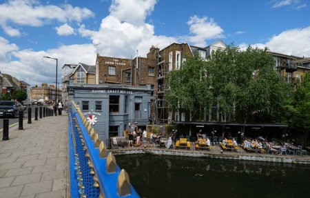 Photo for London - 05 21 2022: View from Ponte Bridge 4c of Maida Hill neighborhood on Grand Union Canal with people at restaurant - Royalty Free Image