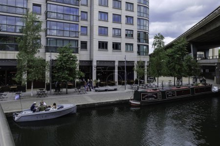 Téléchargez les photos : Londres - 05 29 2022 : Vue du bassin de Paddington depuis la passerelle centrale de Paddington avec des bateaux amarrés et des personnes mangeant - en image libre de droit