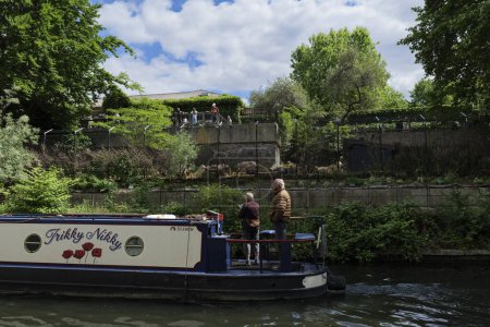 Foto de Londres - 29 05 2022: Casa flotante navegando a lo largo del Regent 's Canal cerca del recinto warthog en el Zoológico de Londres. - Imagen libre de derechos