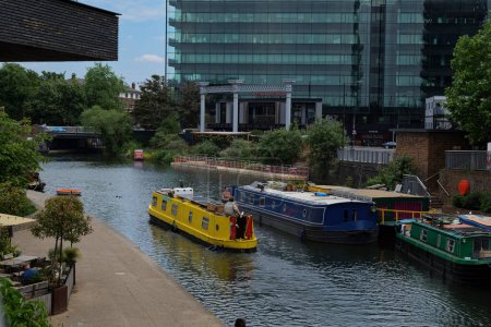 Photo for London - 06 03 2022: Yellow houseboat sails along the Regent's Canal - Royalty Free Image