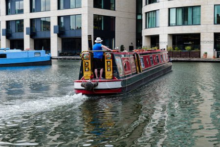 Téléchargez les photos : Londres - 06 03 2022 : Un marin amène un navire touristique au port sur le canal Regent près du bassin de Battlebridge - en image libre de droit