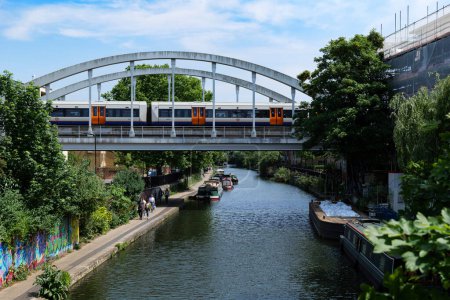 Foto de Londres - 06 04 2022: Tren que cruza el puente ferroviario cerca del Puente Haggerston sobre el Canal Regente - Imagen libre de derechos