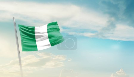 Photo for Nigeria waving flag in beautiful sky. - Royalty Free Image
