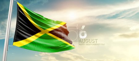 Foto de Jamaica ondeando bandera en hermoso cielo con sol - Imagen libre de derechos