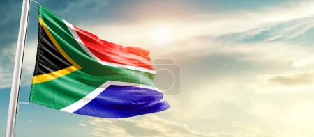 Foto de South Africa waving flag in beautiful sky with sun - Imagen libre de derechos