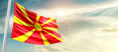 Téléchargez les photos : North Macedonia waving flag in beautiful sky with sun - en image libre de droit