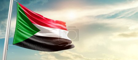 Foto de Sudán ondeando bandera en hermoso cielo con sol - Imagen libre de derechos