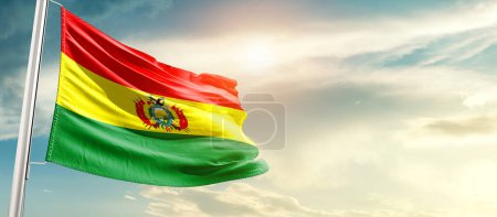 Photo for Bolivia waving flag in beautiful sky with sun - Royalty Free Image