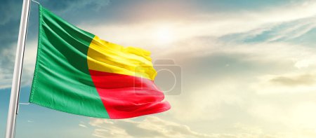 Photo for Benin waving flag in beautiful sky with sun - Royalty Free Image