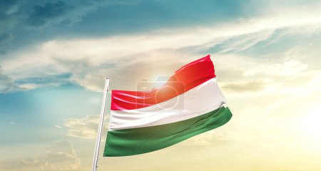 Téléchargez les photos : Hongrie agitant le drapeau dans un ciel magnifique avec le soleil - en image libre de droit