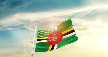 Téléchargez les photos : Dominica waving flag in beautiful sky with sun - en image libre de droit