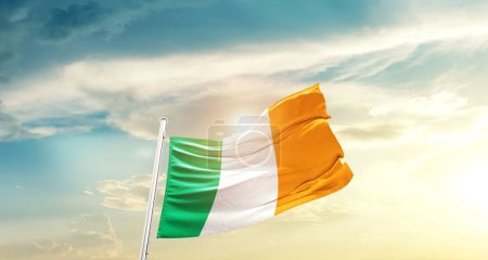 Photo for Ireland waving flag in beautiful sky with sun - Royalty Free Image