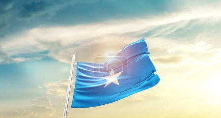 Téléchargez les photos : Somalia waving flag in beautiful sky with sun - en image libre de droit